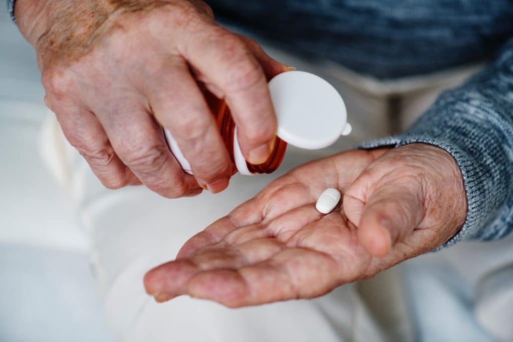 Man with Uloric pill in palm of hand