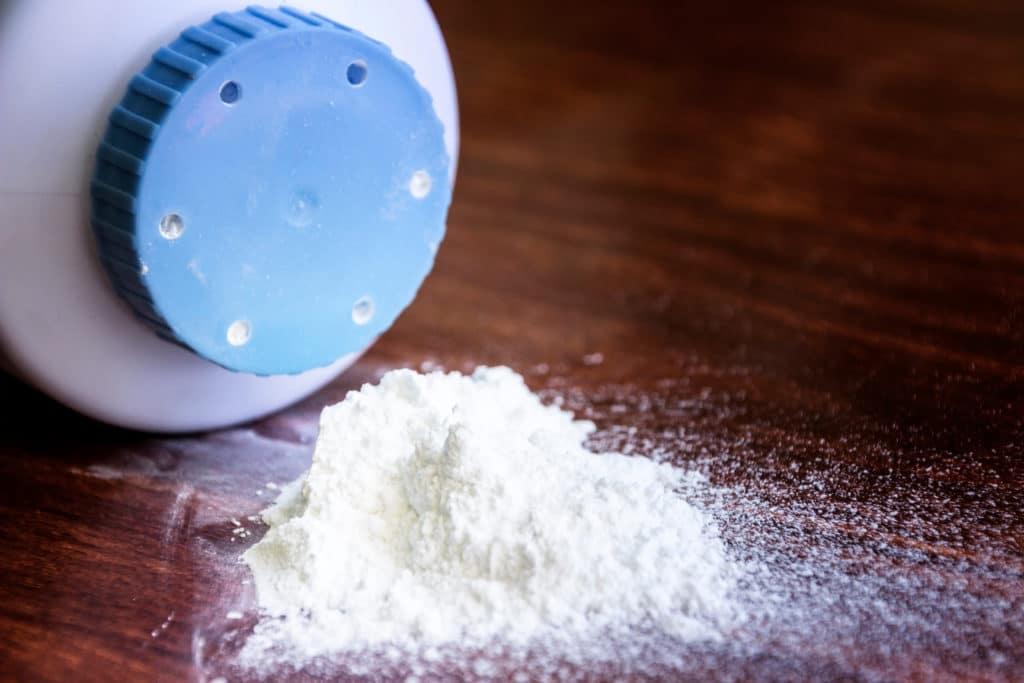 talcum powder bottle with powder spilled on table