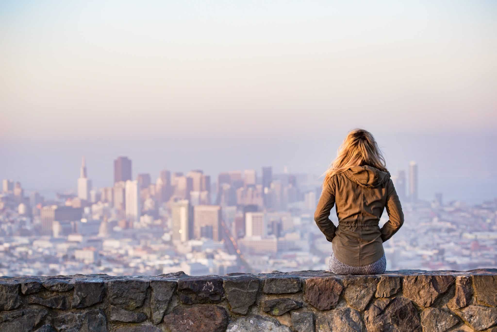 woman on ledge overlooking New York skyline