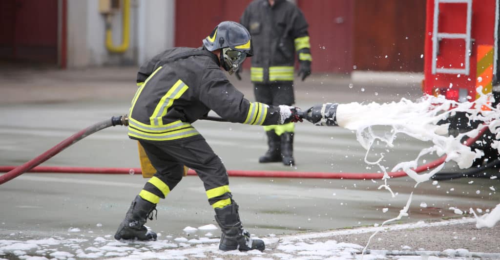 Firefighter fighting a fire with firefighting foam