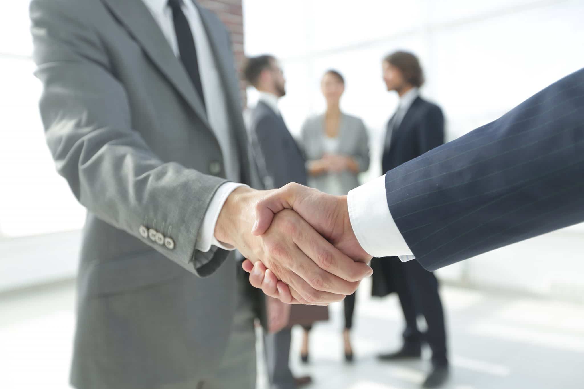 two lawyers shaking hands with people watching