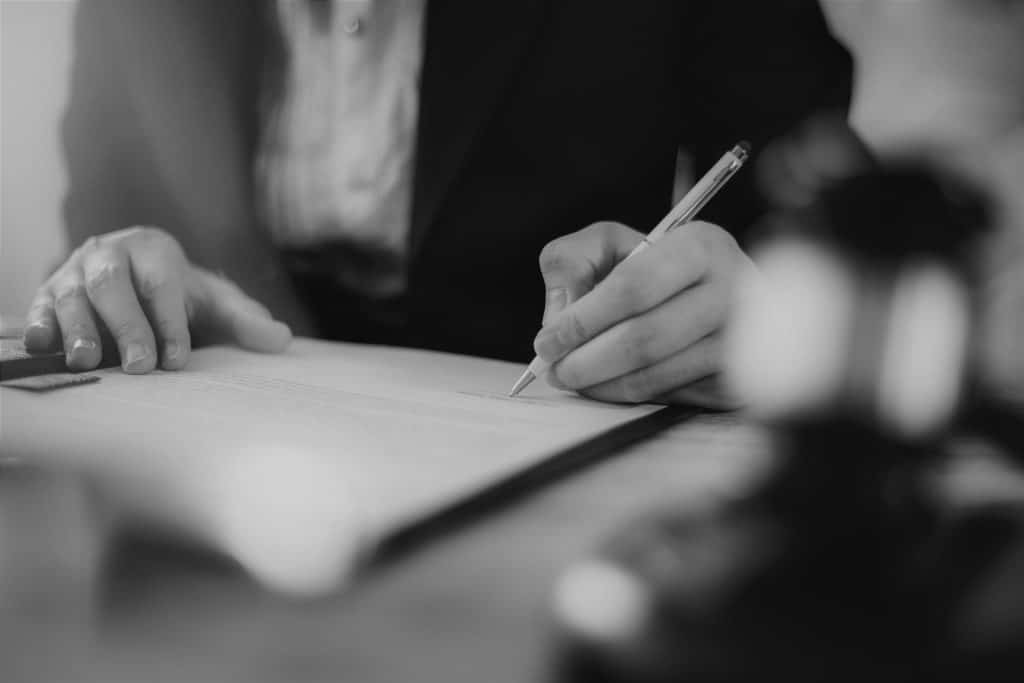 black and white photo of attorney signing a contract